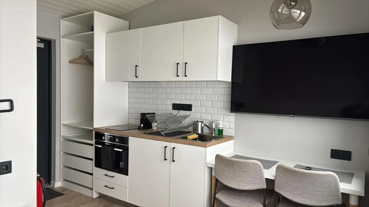 Private kitchen with TV in a cabin at Landbrot Guesthouse